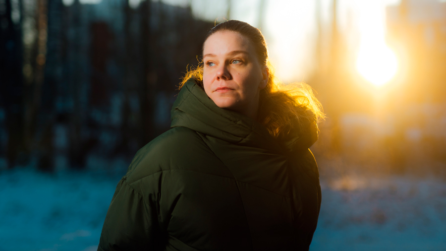 Henkilö talvisessa maisemassa auringonlaskun aikaan.