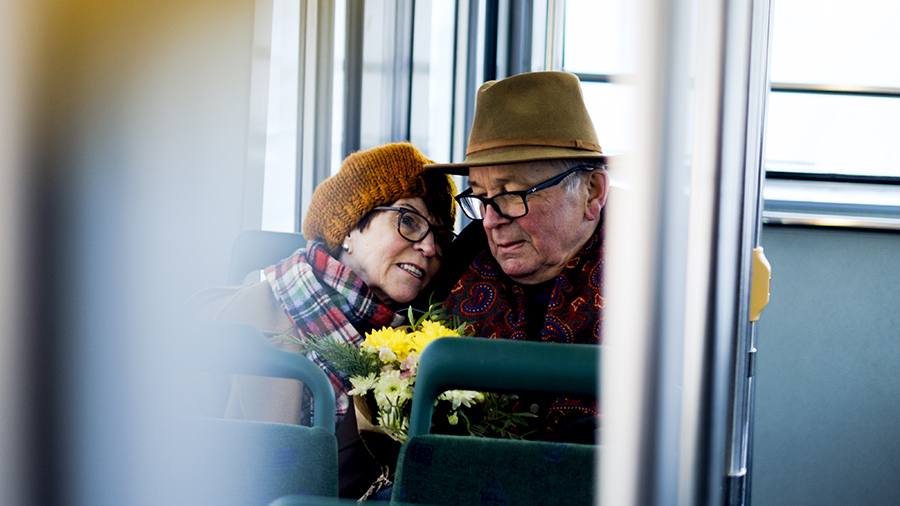Äldre kvinna och man i spårvagn.